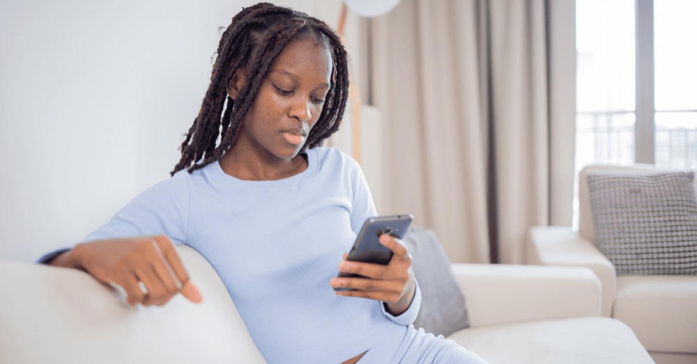 A woman relaxing on a sofa with her phone